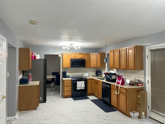 a kitchen with kitchen island granite countertop a sink cabinets and stainless steel appliances