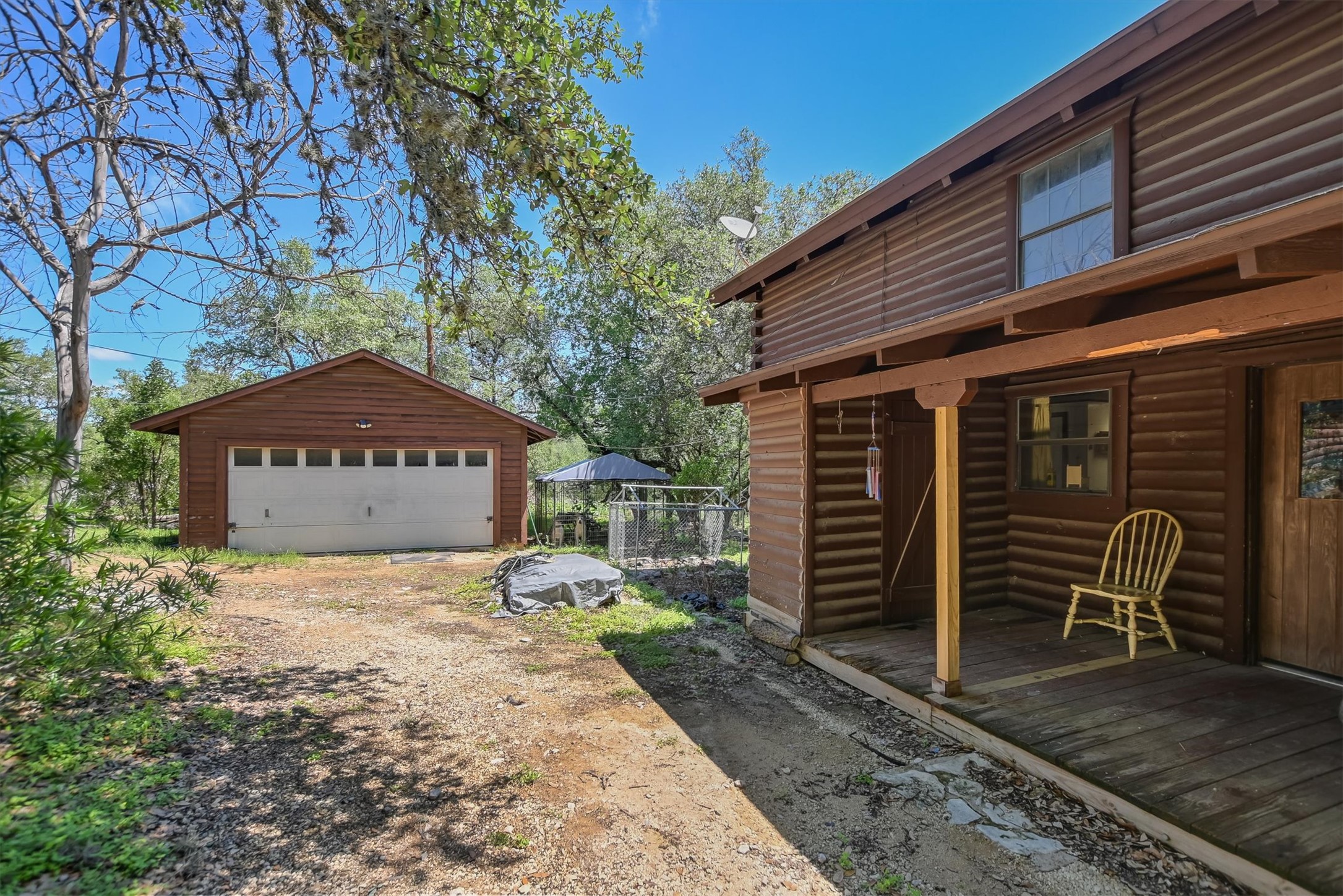 12711 Rr, Unit 12 Wimberley, TX 78676 - Photo 2 of 20 The entrance to the Wimberley residence features a gravel drive leading to the detached two-car garage