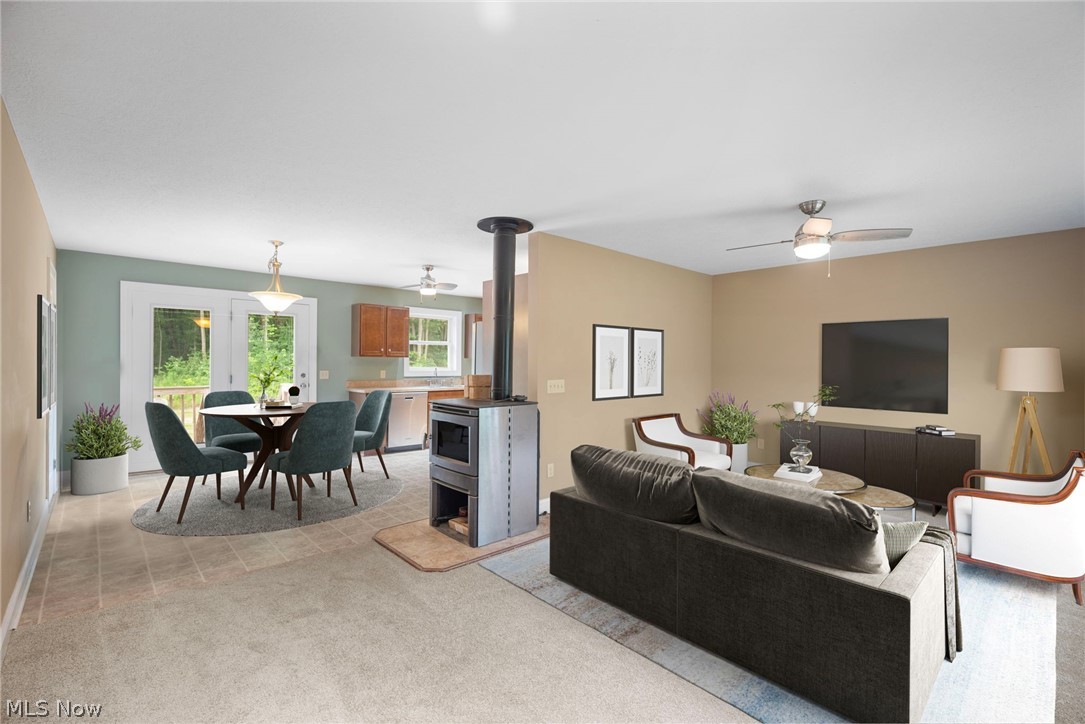 16985 Moseley Road Thompson, OH 44086 - Photo 6 of 22 Living room featuring light carpet, ceiling fan, and a wood stove