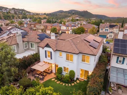 an aerial view of residential houses with outdoor space and parking