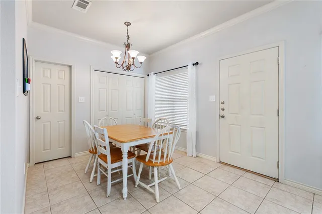 a view of a dining room with furniture and chandelier