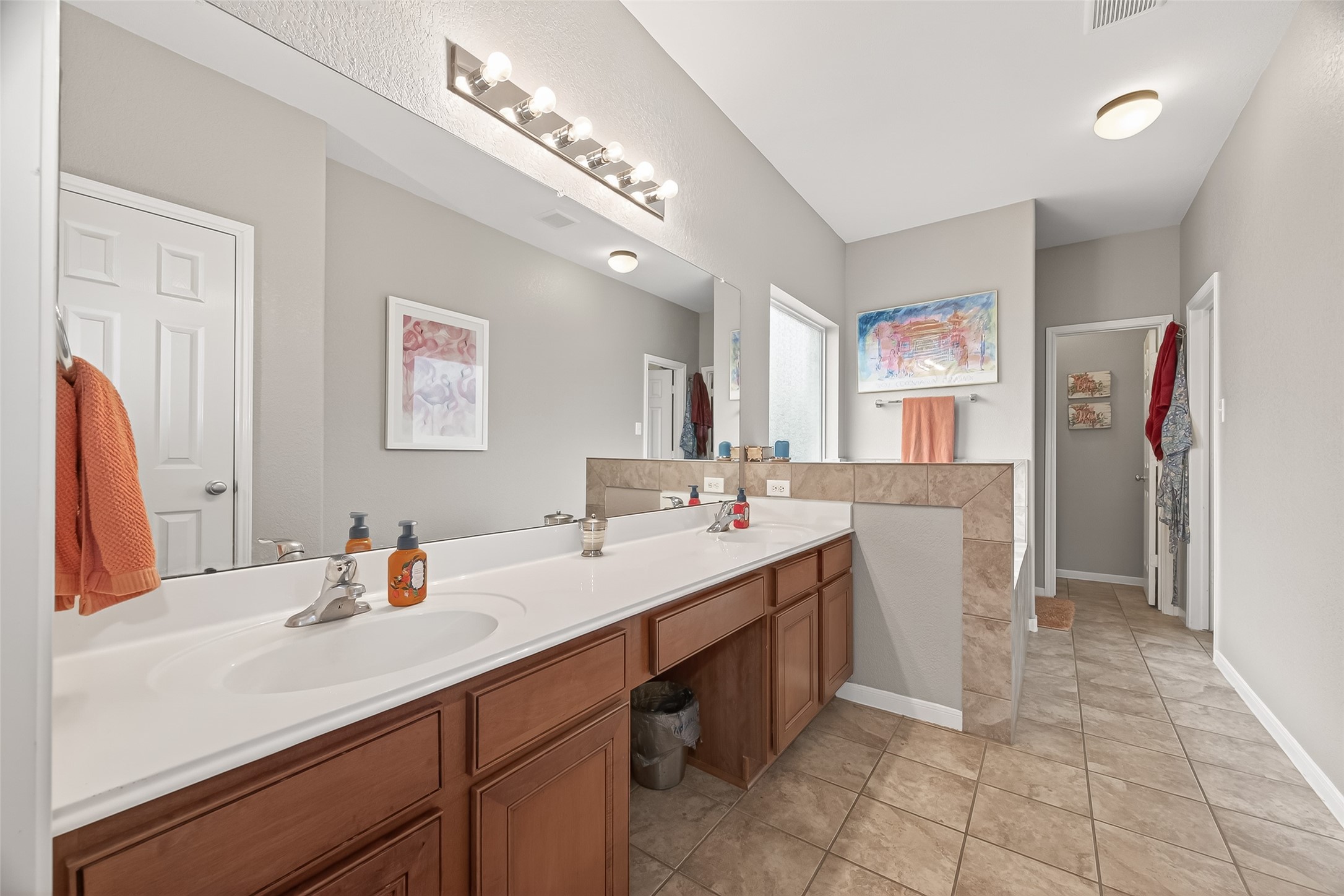 9110 Cavalier Lane Rosenberg, TX 77469 - Photo 24 of 30 The en suite bathroom features a spacious double vanity with ample storage, a large mirror with modern lighting, and a neutral color scheme. The tile flooring and separate shower area enhance its functionality and style.