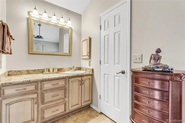 a bathroom with a granite countertop sink vanity and a mirror