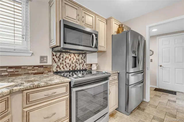 a kitchen with stainless steel appliances granite countertop a stove microwave and refrigerator