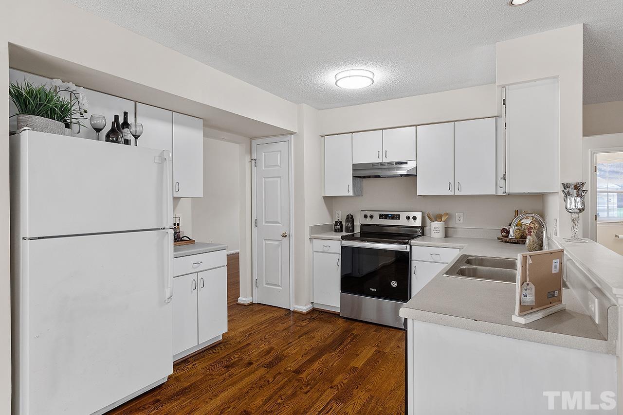 5504 Botany Bay Drive Raleigh, NC 27616 - Photo 11 of 23 a kitchen with a refrigerator a stove and white cabinets