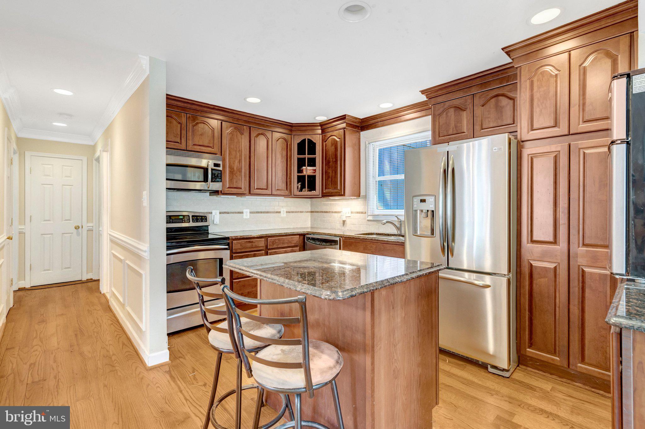 8844 McGrath Road Manassas, VA 20112 - Photo 12 of 27 Modern kitchen with rich wood accents.