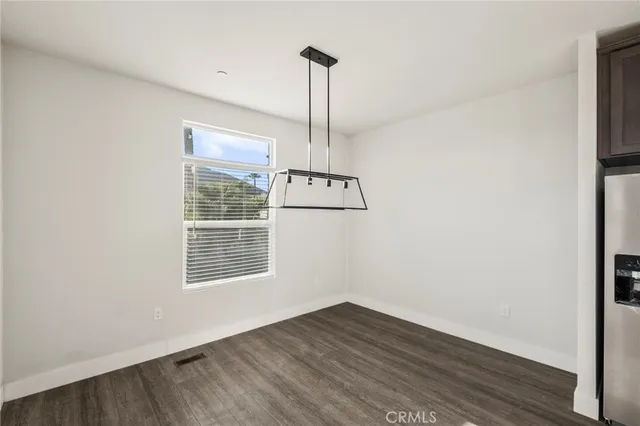 a large kitchen with stainless steel appliances lots of counter space and wooden floor