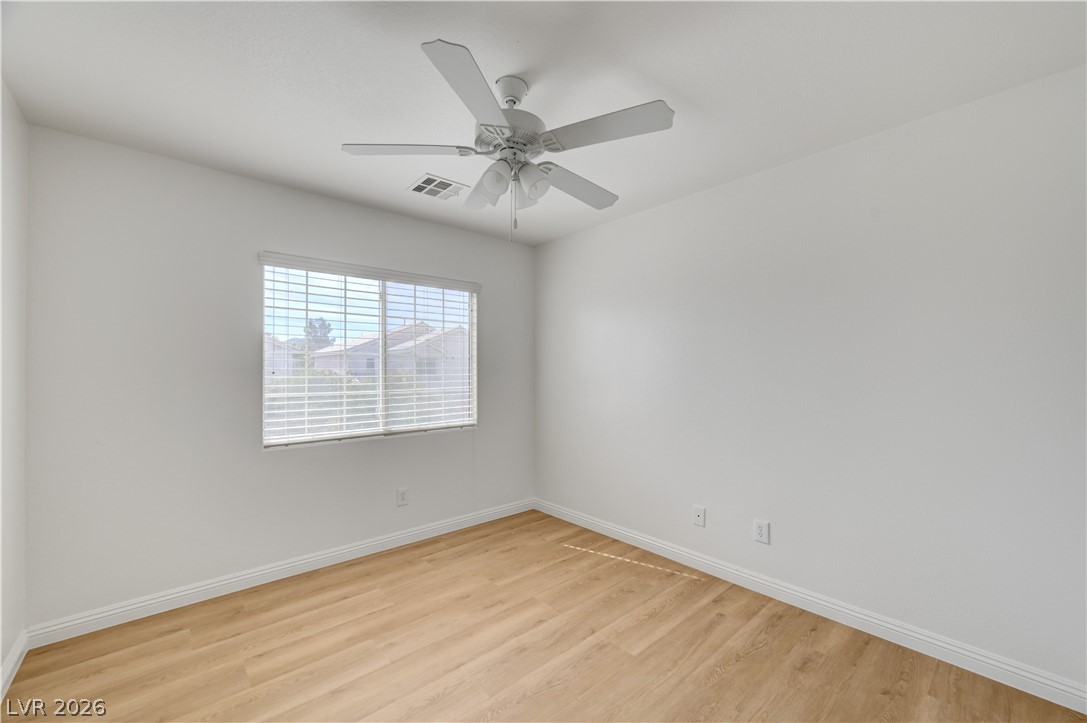 8918 Houston Ridge Avenue Las Vegas, NV 89178 - Photo 29 of 35 A well-lit bedroom with light wood flooring and a refreshing ceiling fan.