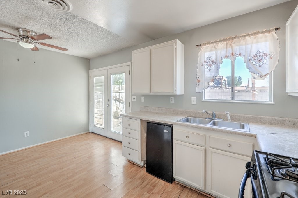 3948 Maple Hill Road Las Vegas, NV 89115 - Photo 4 of 20 Kitchen featuring white cabinetry, visible vents, range with gas cooktop, ceiling fan, and a sink