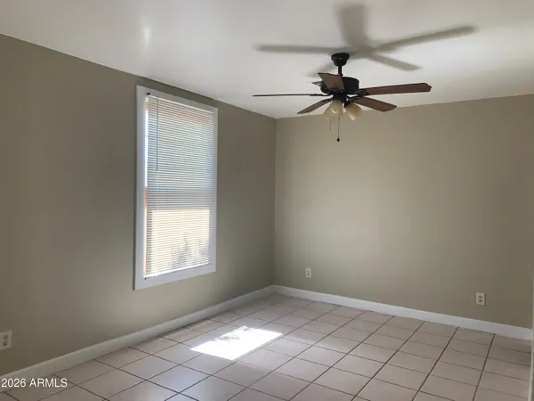 an empty room with windows and fan