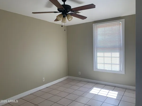 an empty room with a window and a fan