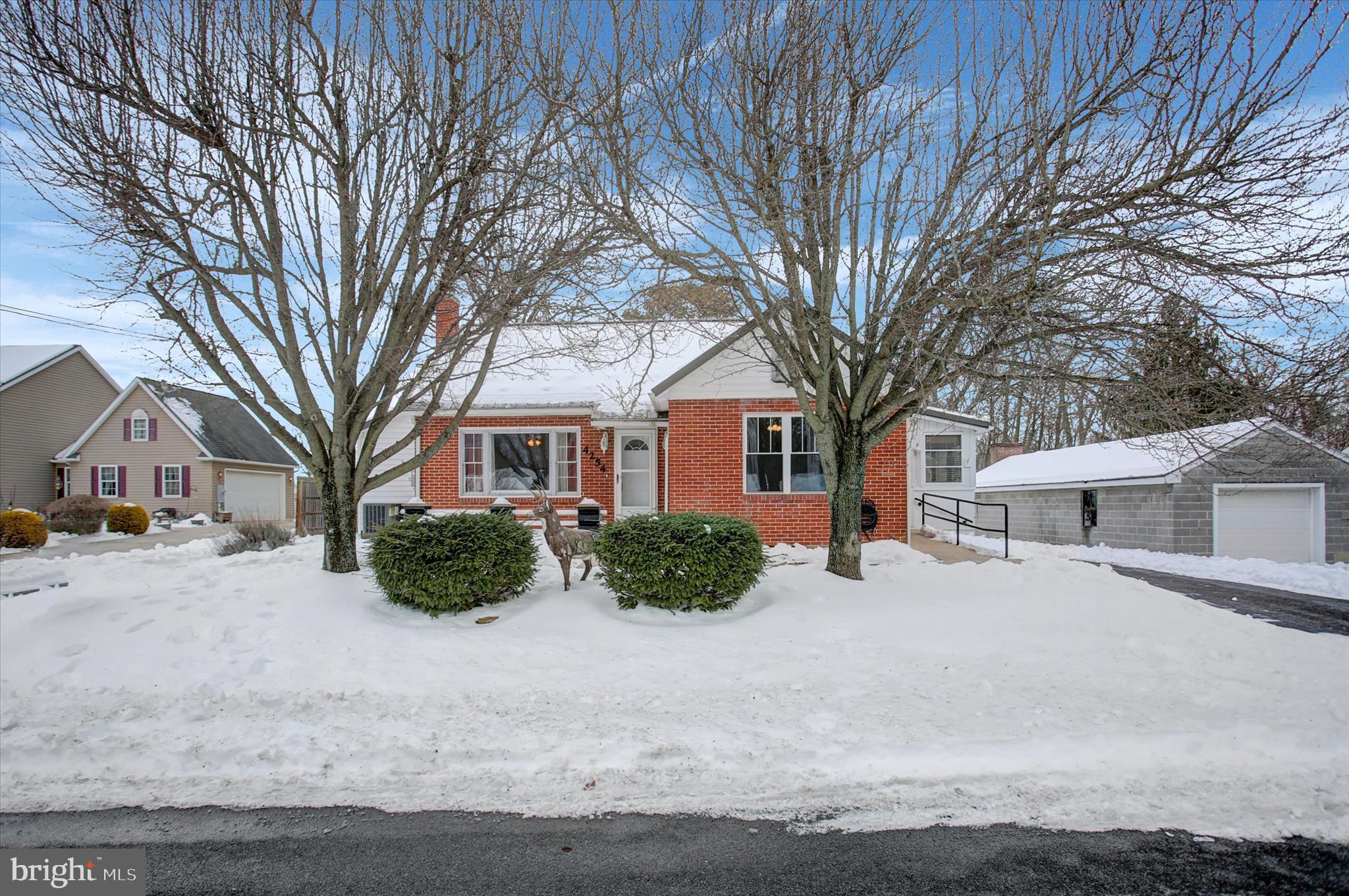 a front view of a house with a yard covered in snow