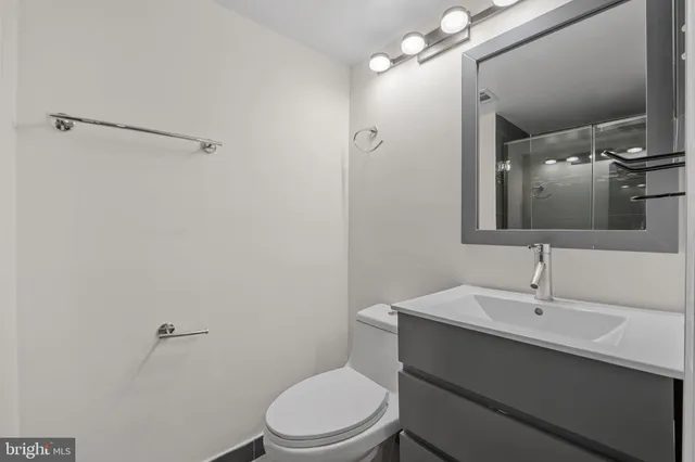 a bathroom with a toilet a sink and mirror