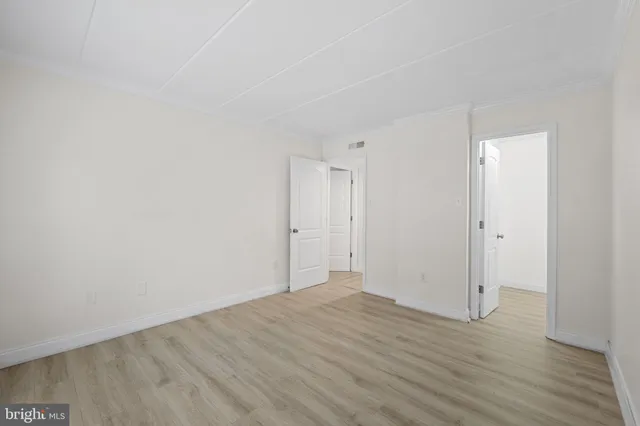 a view of an empty room with wooden floor