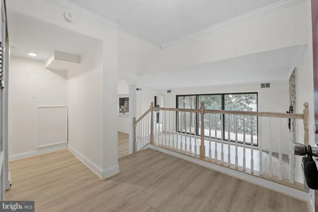 a view of a hallway with wooden floor and windows
