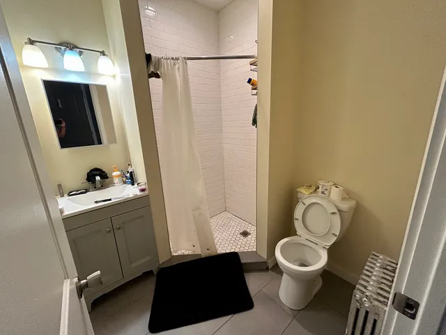a bathroom with a toilet sink a mirror a vanity and shower