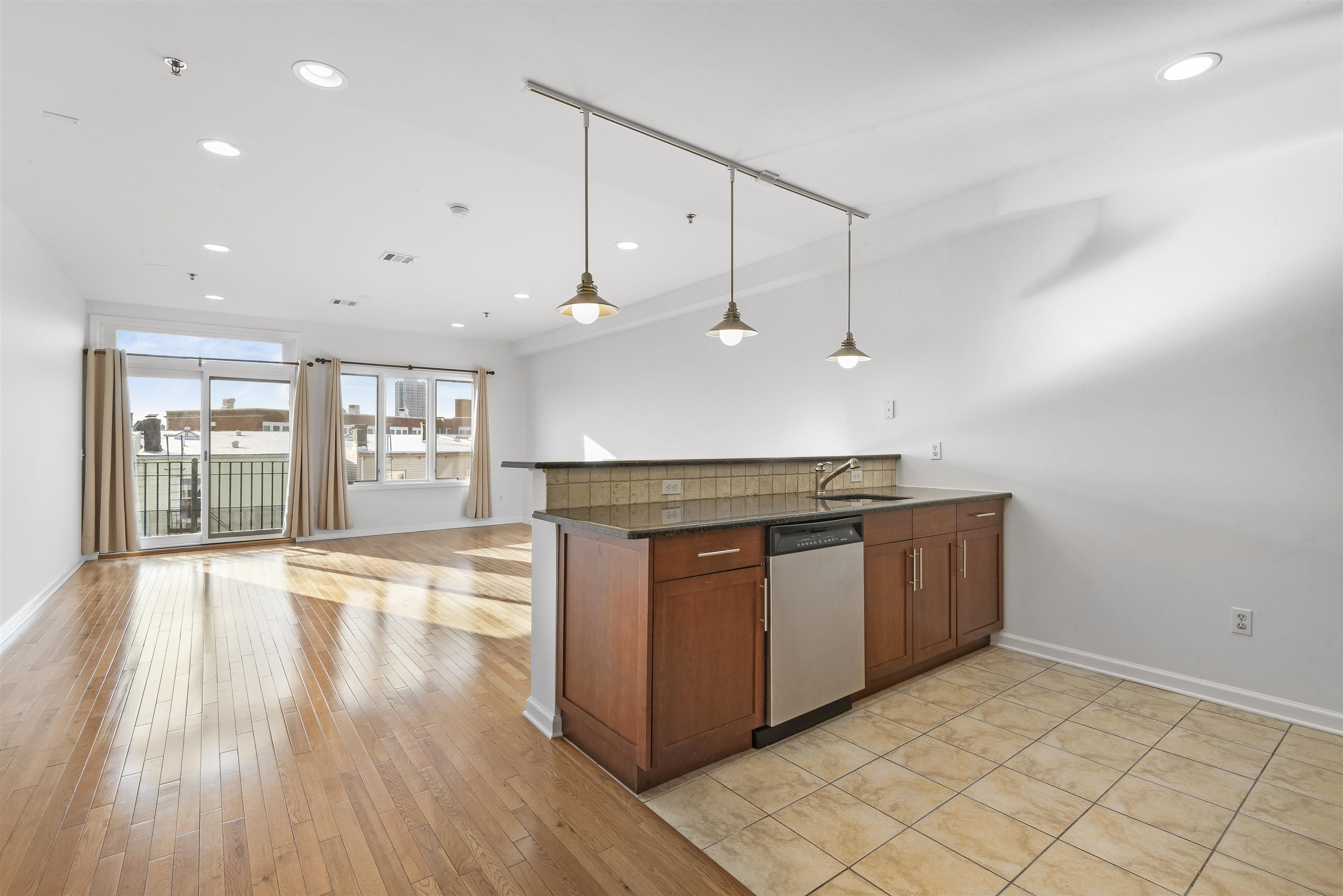 203-207 Hackensack Plank Road, Unit 5B Weehawken, NJ 07086 - Photo 3 of 18 a kitchen with stainless steel appliances granite countertop a sink a stove and a wooden floors