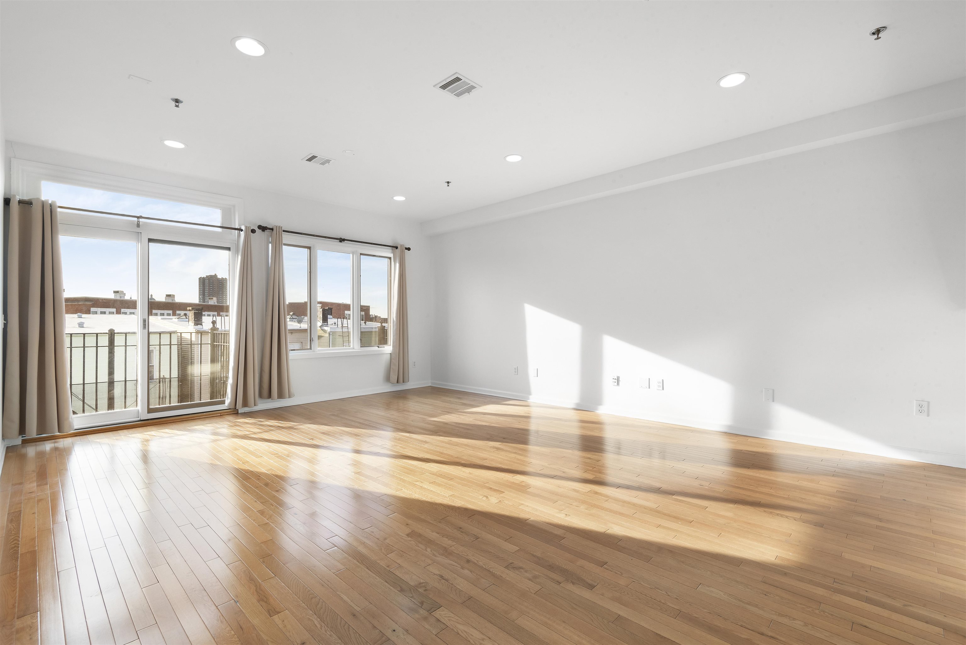 203-207 Hackensack Plank Road, Unit 5B Weehawken, NJ 07086 - Photo 5 of 18 a view of an empty room with wooden floor and a window
