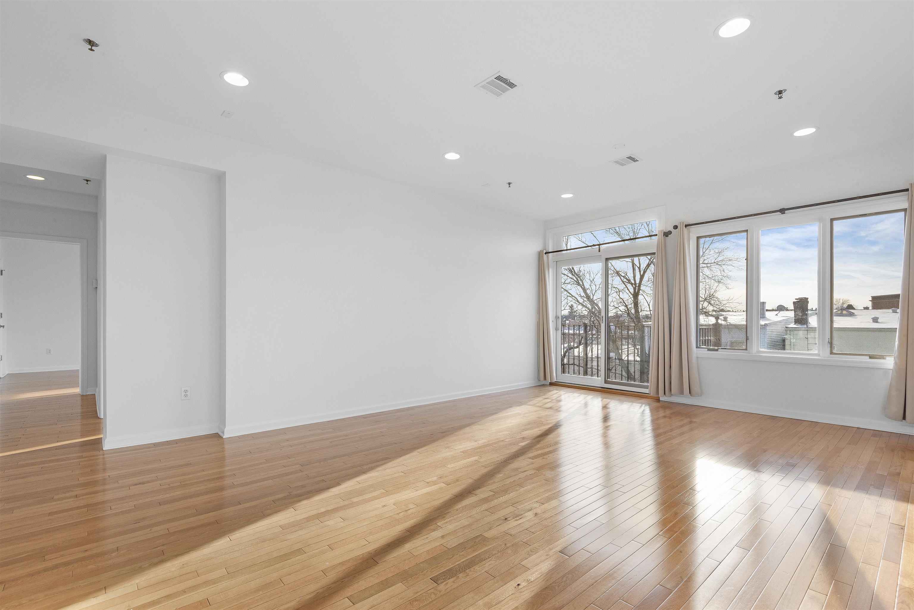 203-207 Hackensack Plank Road, Unit 5B Weehawken, NJ 07086 - Photo 7 of 18 a view of an empty room with wooden floor and a window