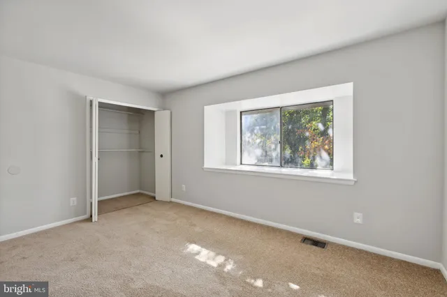 an empty room with windows and closet