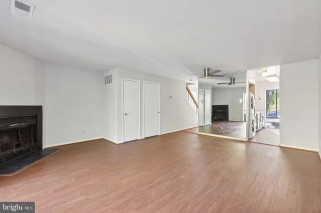 a view of empty room with wooden floor and fireplace