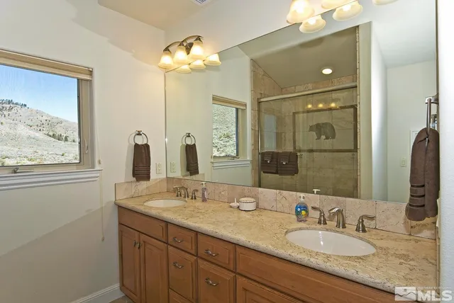 a bathroom with a granite countertop toilet sink and mirror
