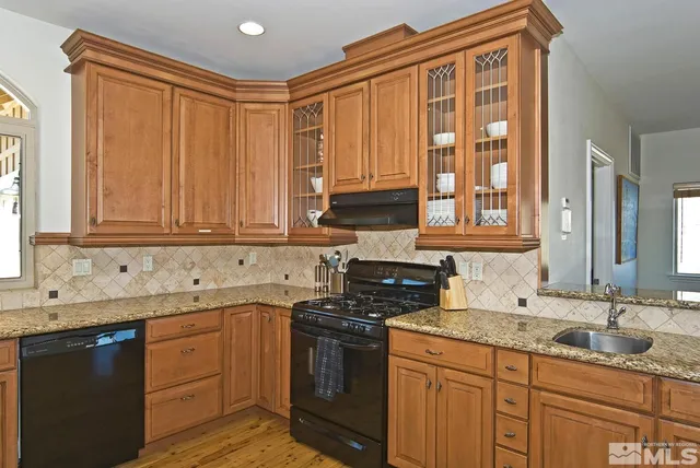a kitchen with stainless steel appliances granite countertop a stove a sink dishwasher and a microwave oven with cabinets