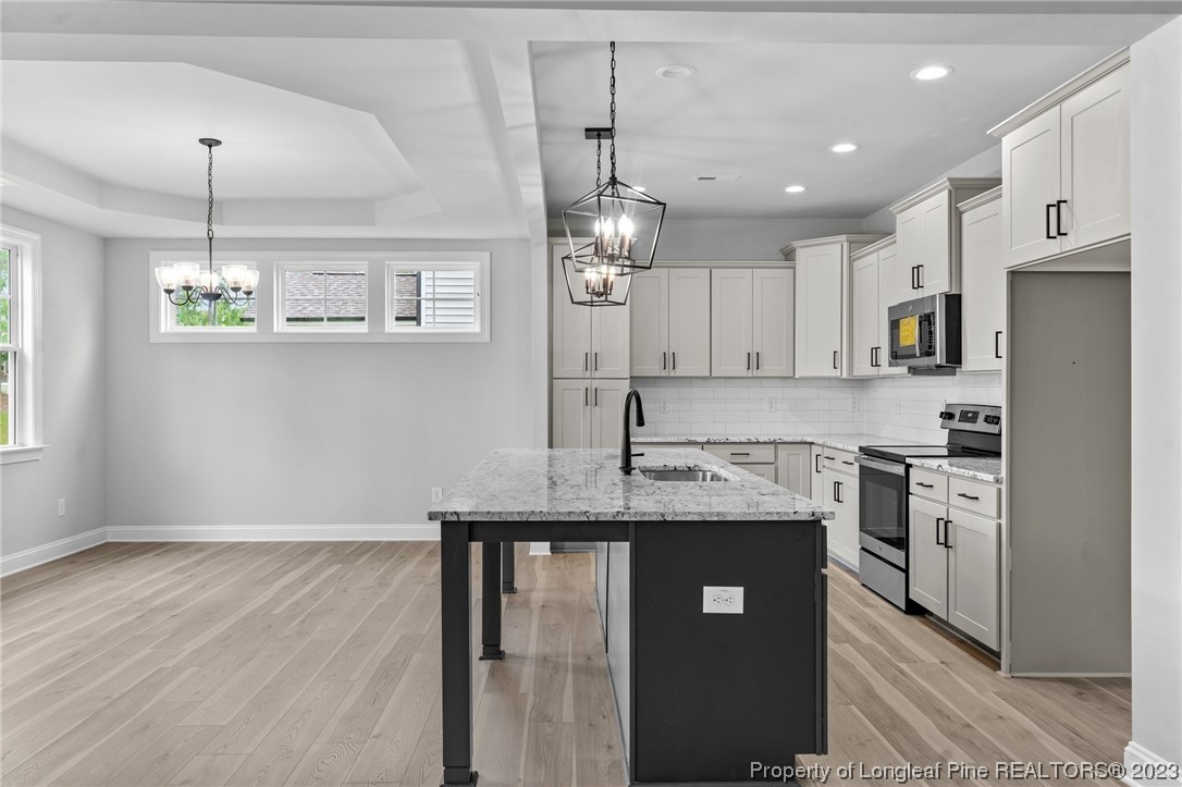 144 Kensington Dr Spring Lake Spring Lake, NC 28390 - Photo 6 of 22 a kitchen with kitchen island granite countertop stainless steel appliances cabinets a sink and a counter top