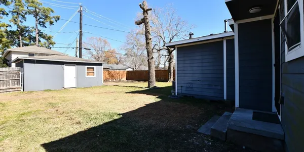 a backyard of a house with wooden fence and trees