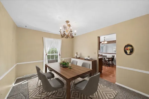 a view of a dining room with furniture and chandelier