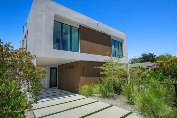 a front view of a house with plants