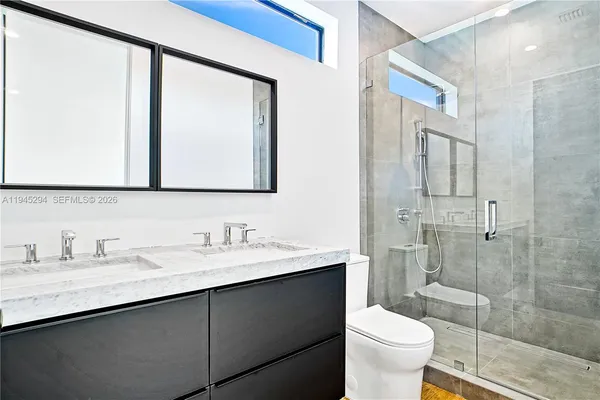 a bathroom with a sink a toilet and shower
