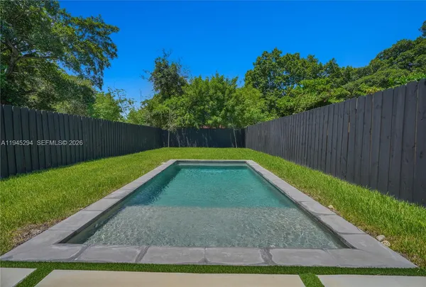 a view of backyard with wooden fence