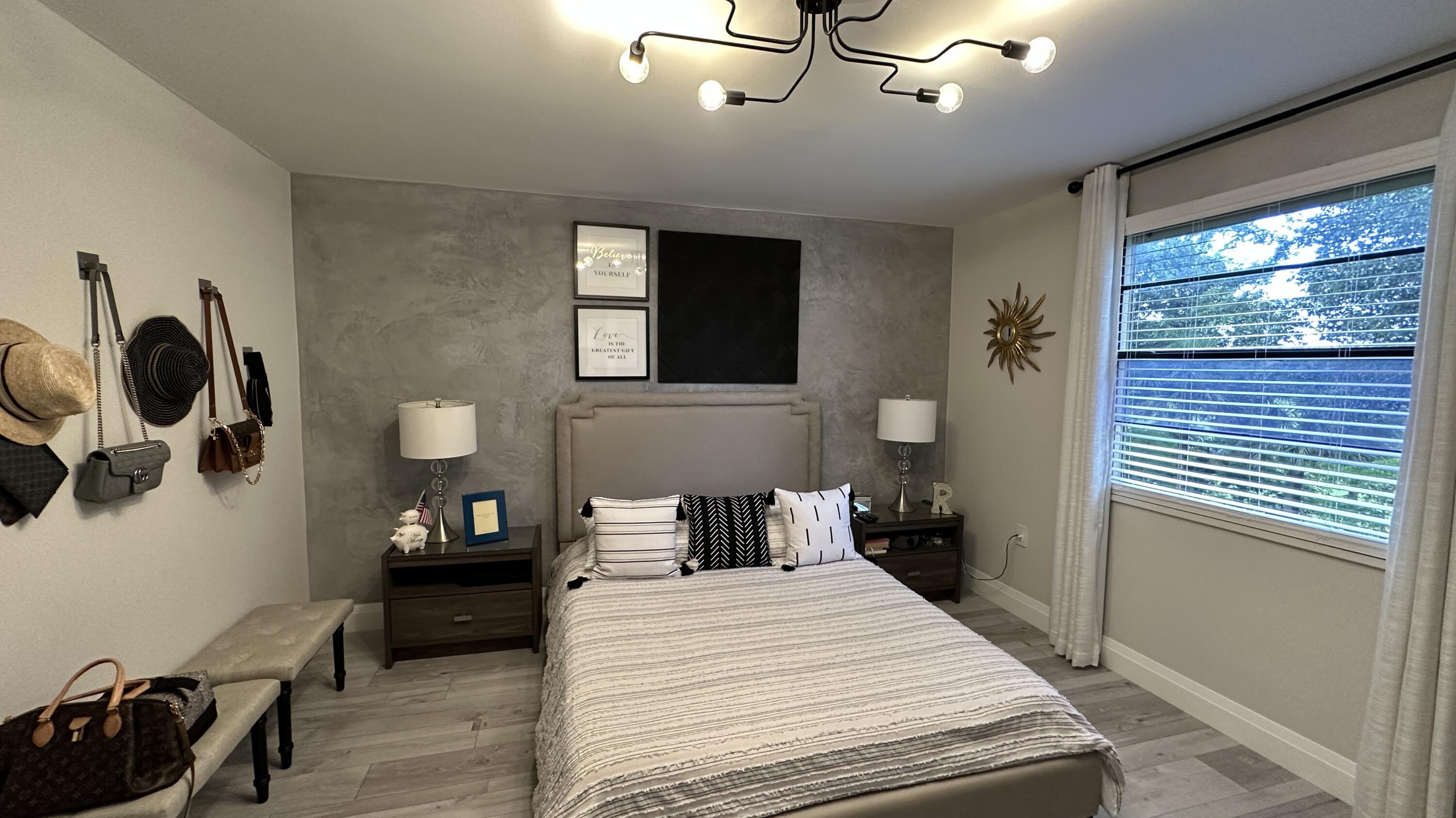 6073 Balboa Circle, Unit 305 Boca Raton, FL 33433 - Photo 14 of 29 a bedroom with a bed and wooden floor
