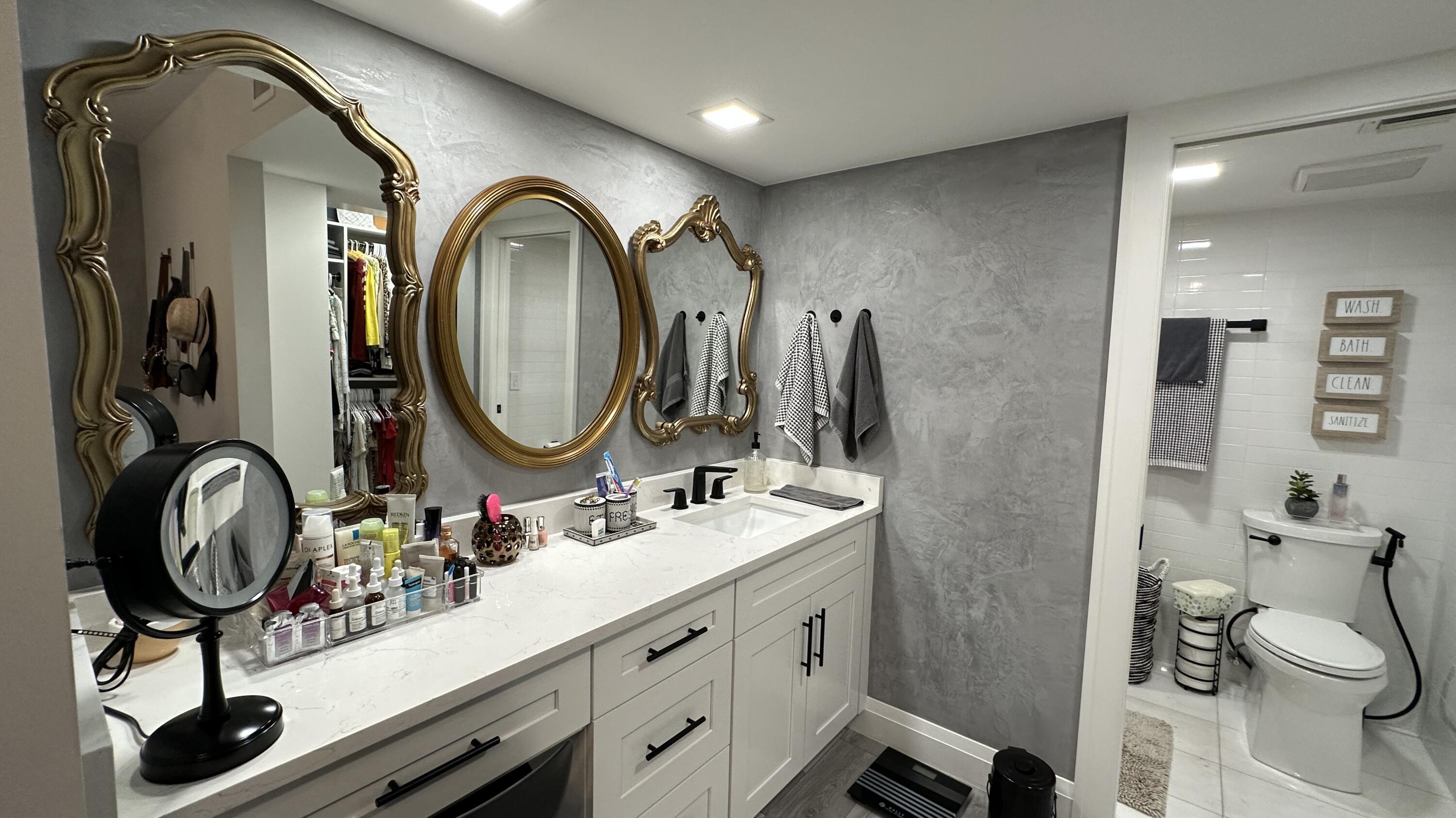 6073 Balboa Circle, Unit 305 Boca Raton, FL 33433 - Photo 16 of 29 a bathroom with a toilet a sink and a mirror
