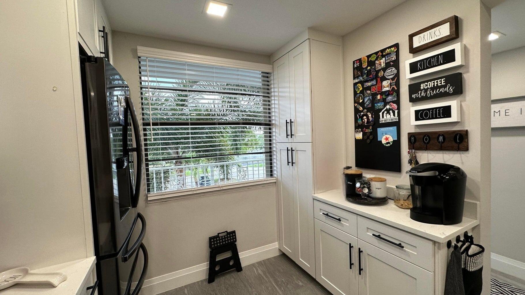 6073 Balboa Circle, Unit 305 Boca Raton, FL 33433 - Photo 5 of 29 a kitchen with stainless steel appliances a sink a window and cabinets