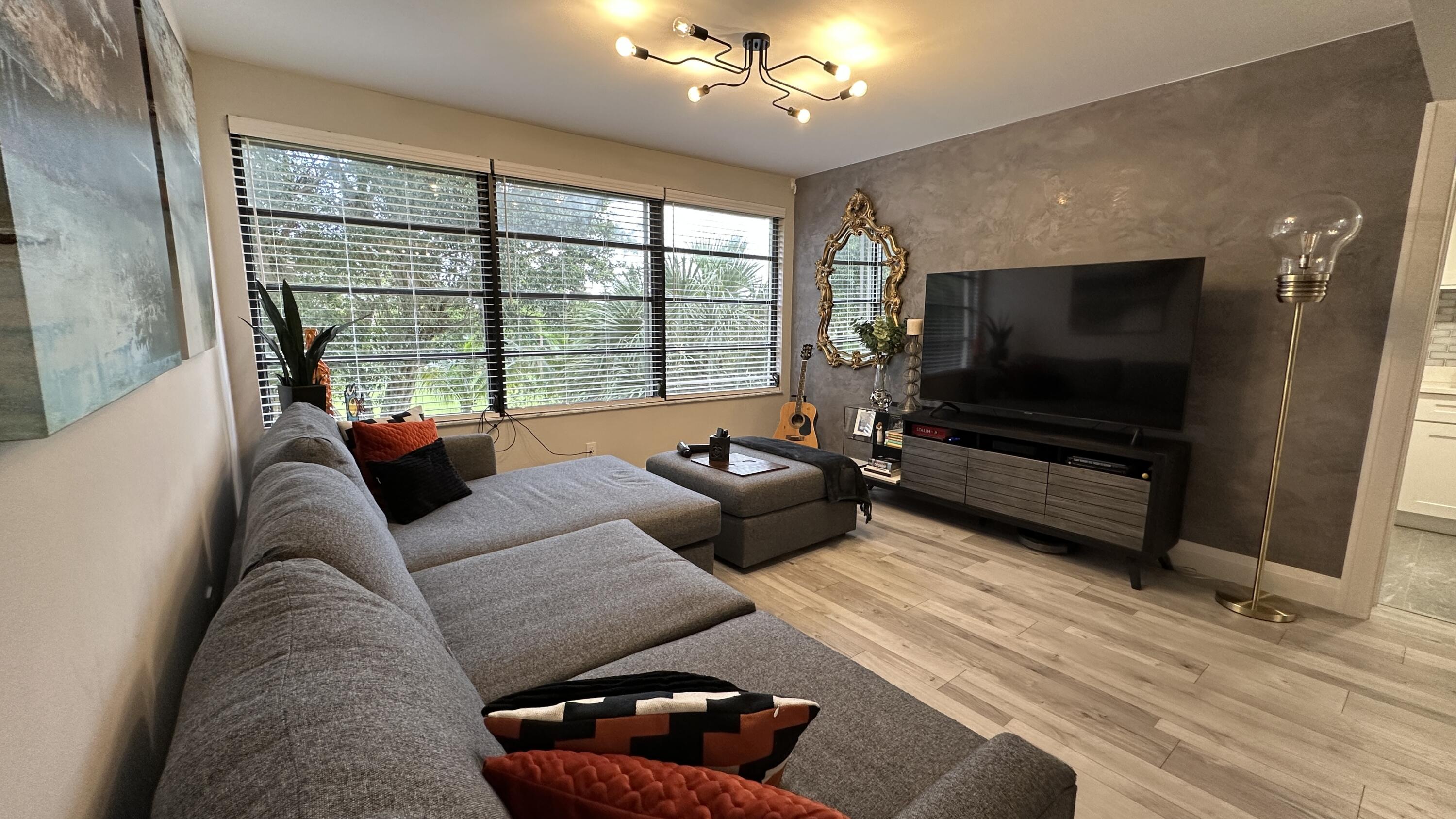 6073 Balboa Circle, Unit 305 Boca Raton, FL 33433 - Photo 10 of 29 a living room with furniture and a flat screen tv