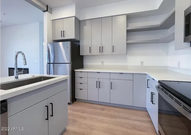 a kitchen with white cabinets sink and stainless steel appliances