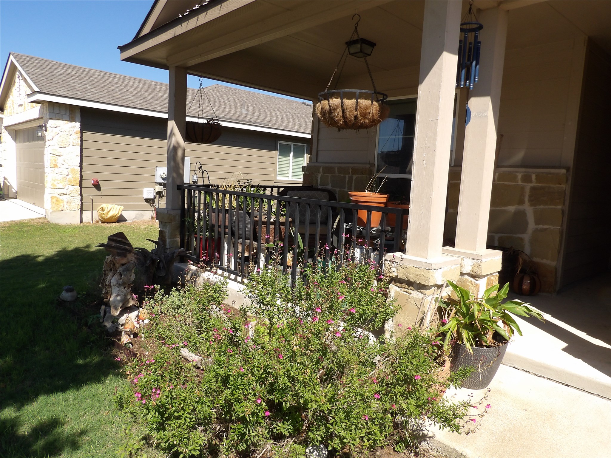 930 Pumpkin Ridge New Braunfels, TX 78130 - Photo 31 of 32 Covered front porch featuring stone-clad pillars, wrought iron railing, and a concrete floor
