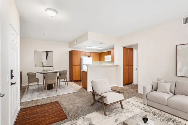 a living room with furniture a dining table and a refrigerator