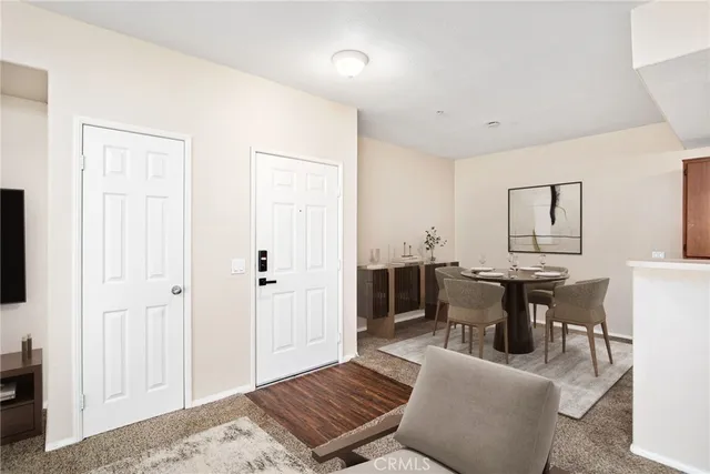 a living room with furniture a flat screen tv and kitchen view