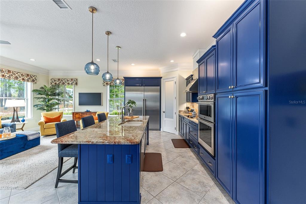 8671 Southwest 83rd Loop Ocala, FL 34481 - Photo 20 of 58 a large kitchen with stainless steel appliances wooden cabinets a center island and a wooden floors