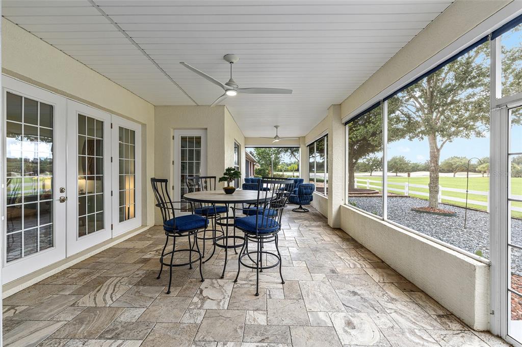 8671 Southwest 83rd Loop Ocala, FL 34481 - Photo 26 of 58 a dining room with furniture a rug and a floor to ceiling window