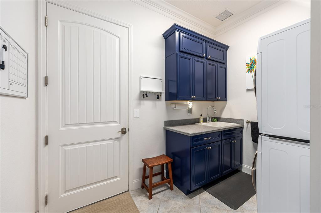 8671 Southwest 83rd Loop Ocala, FL 34481 - Photo 49 of 58 a utility room with cabinets and a refrigerator