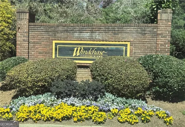 an empty room with wooden floor fireplace and windows