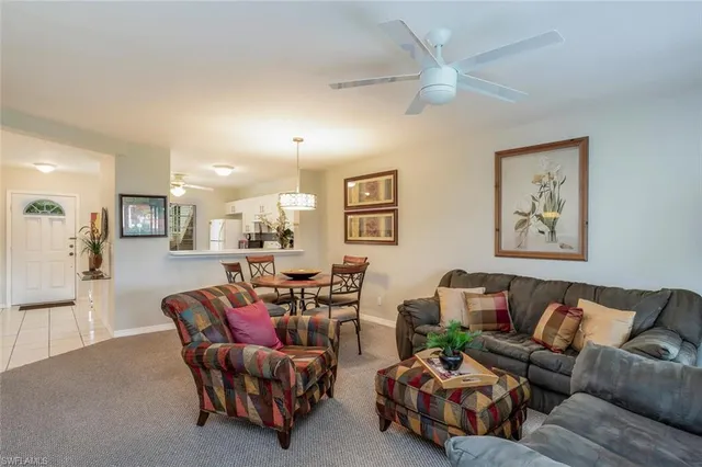a living room with furniture and a view of kitchen