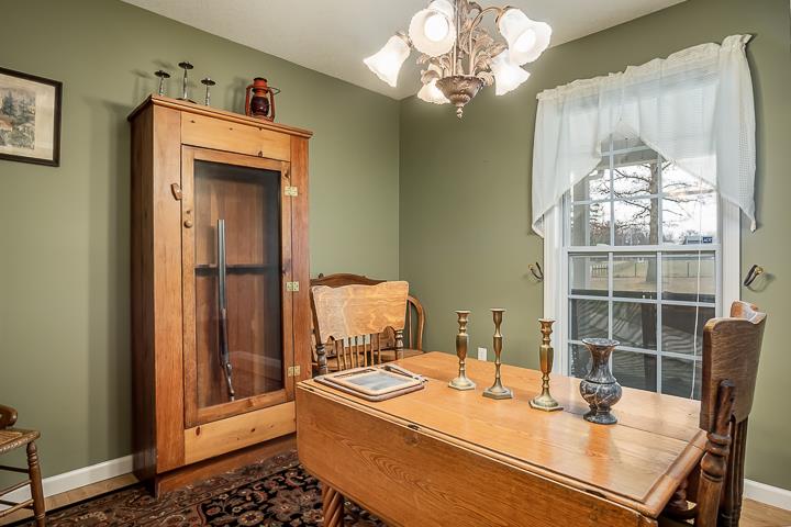 2329 Roslin Road Jamestown, TN 38556 - Photo 23 of 30 a dining room with wooden floor a chandelier a wooden table and chairs