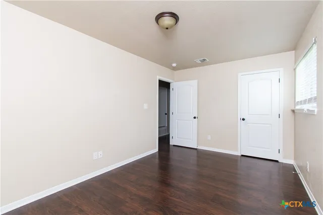 a view of an empty room with wooden floor