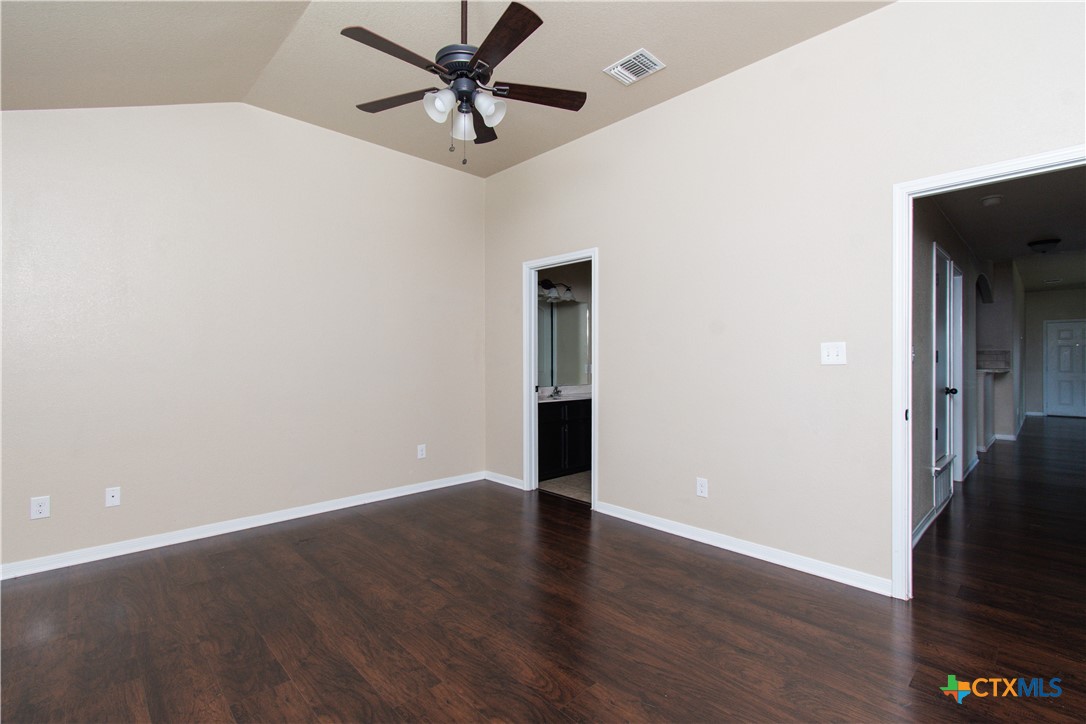 1102 Grace Point Drive, Unit A Killeen, TX 76549 - Photo 15 of 18 an empty room with wooden floor and a ceiling fan
