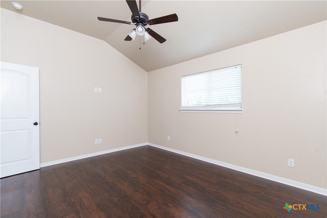 1102 Grace Point Drive, Unit A Killeen, TX 76549 - Photo 16 of 18 an empty room with wooden floor fan and windows